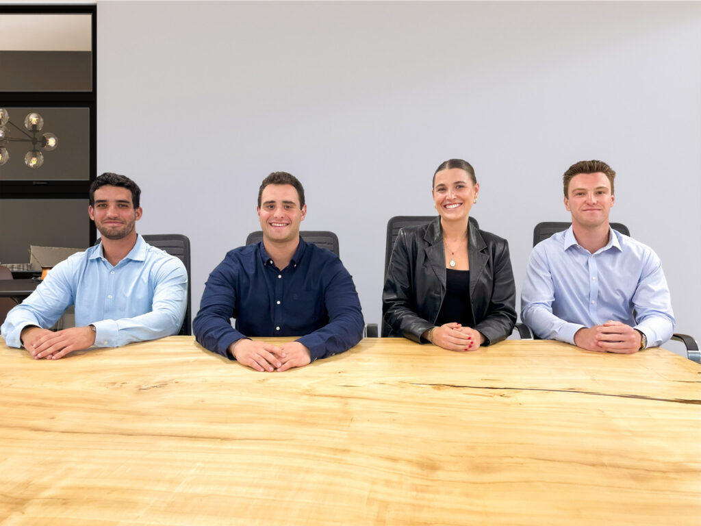 Colrich Interns - 4 people sitting at a wooden conference table